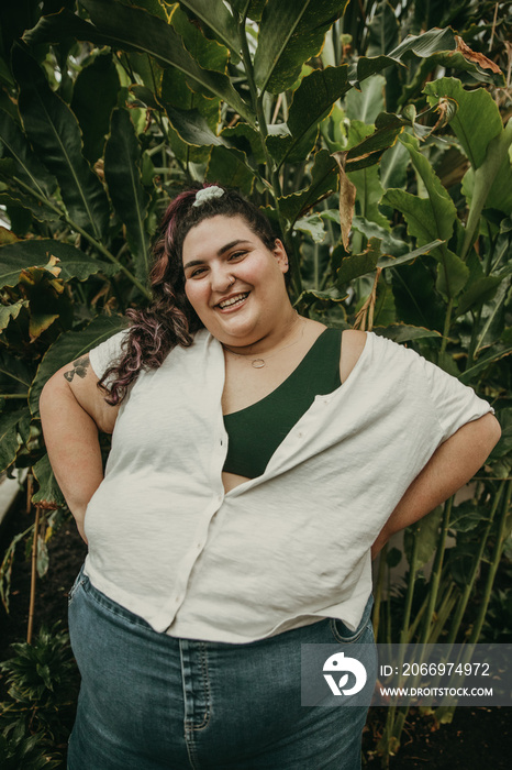 portrait of a plus size jewish woman smiling in front of plants