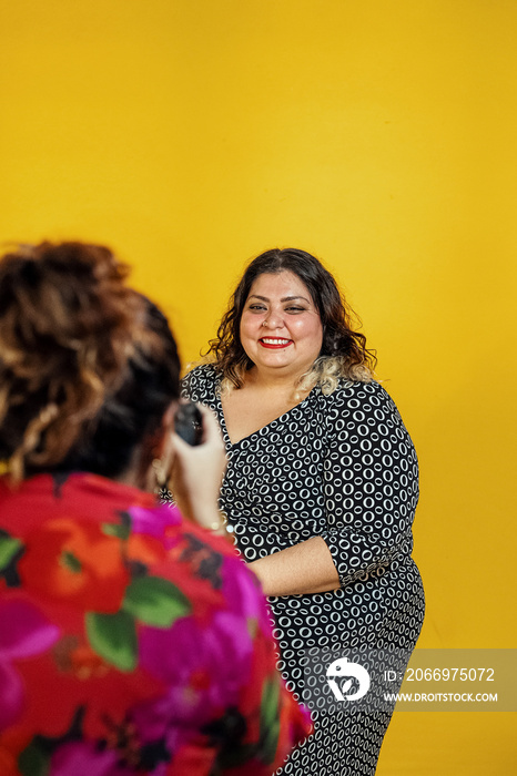 Plus sized female getting her headshots taken by a south asian female photographer