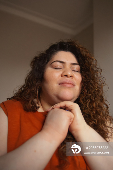 Plus-sized Sri Lankan woman with vitiligo meditating in her bedroom