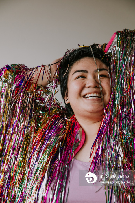 portrait of a plus size woman smiling with tinsel jacket