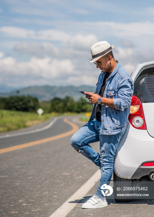 hombre latino escribiendo y llamando por teléfono celular al aire libre