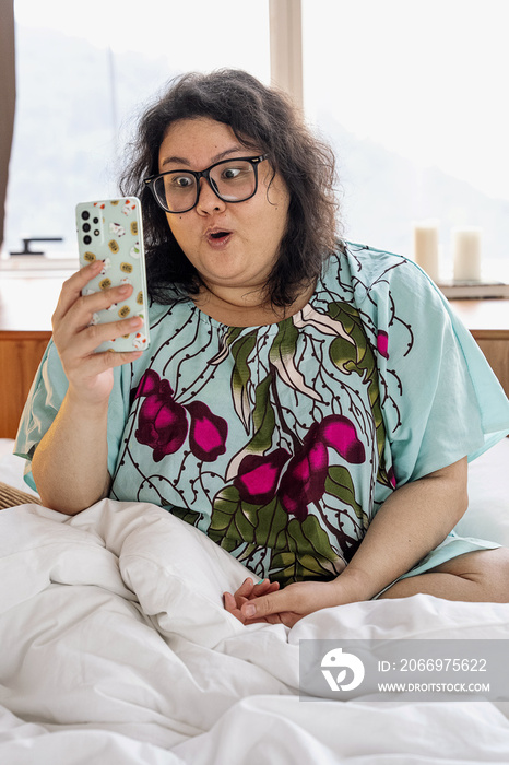 Plus sized female video calling another friend in bed