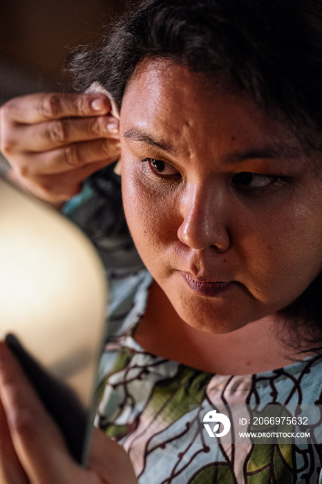 Plus size female removing her make up with a make up wipe