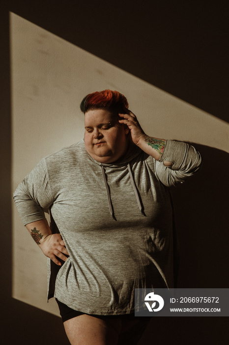 portrait of a plus size woman in the light surrounded by shadow