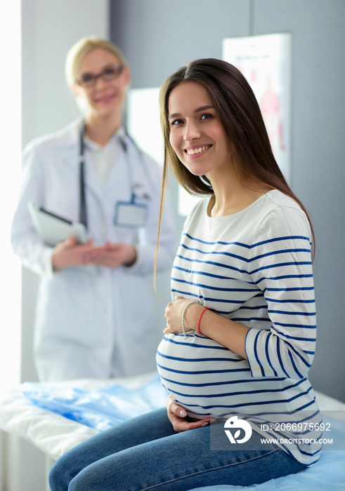 Beautiful smiling pregnant woman with the doctor at hospital