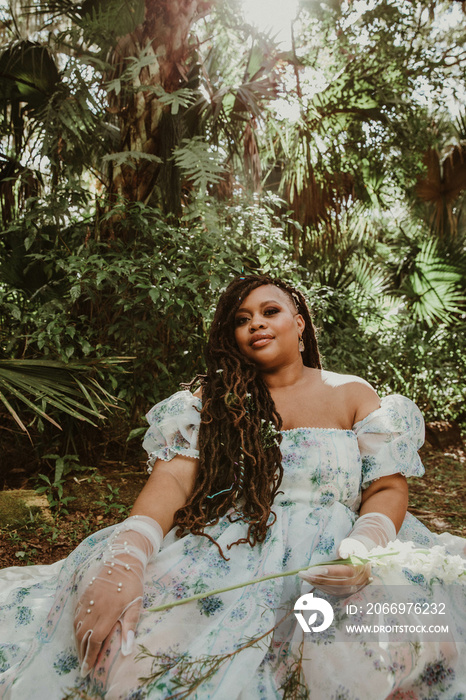 plus size African American woman sitting on the ground in a big dress