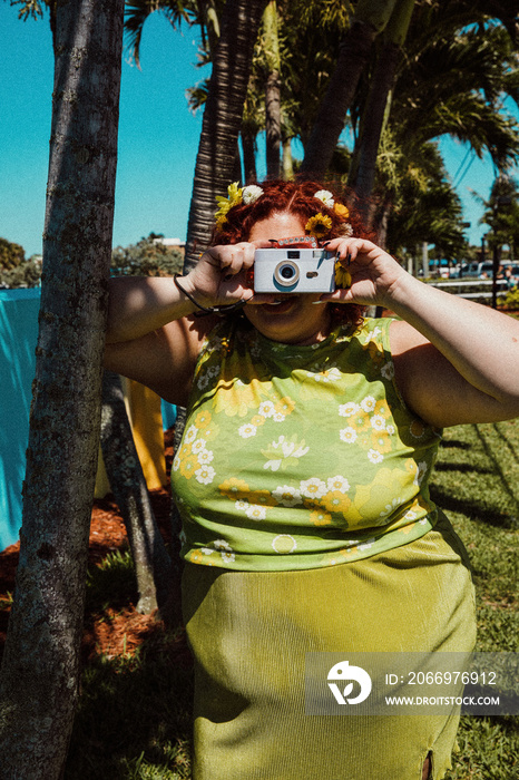 plus size woman taking photo with purple camera