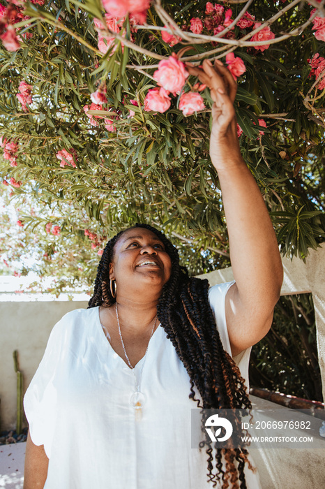 portrait of a plus size afro latinx haitian american woman looking up at flowers