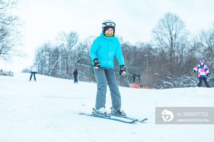 young adult smiling woman skiing down by hill