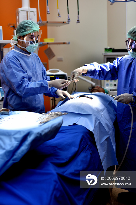 Team surgeon at work in operating room. Surgical light in the operating room. Preparation for the beginning of surgical operation with a cut. The surgeon is performing surgery on the patient.