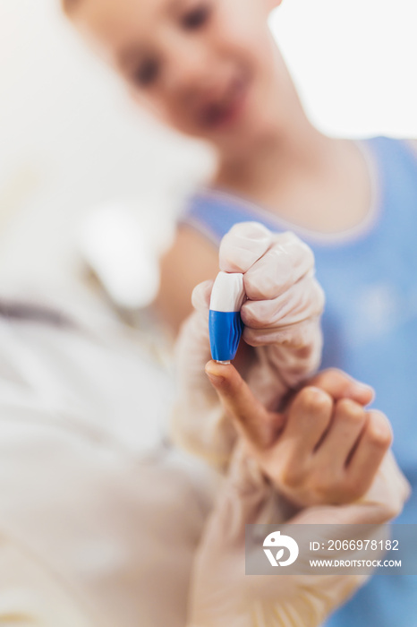 Doctor taking blood test from small patient.