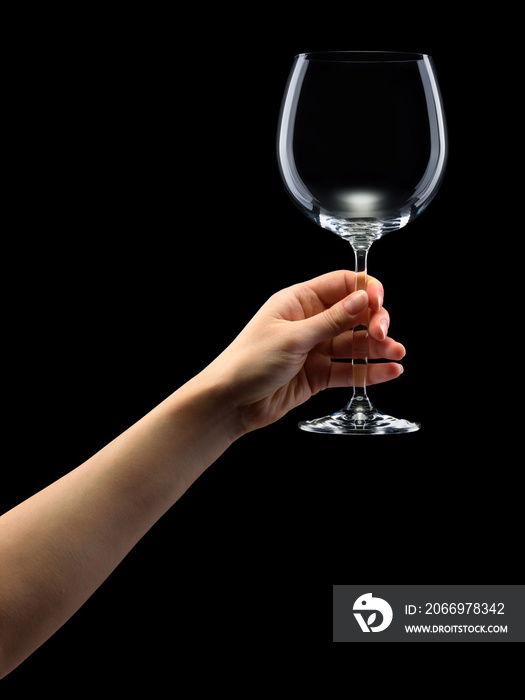 Woman hand holding empty wine glass isolated on black.