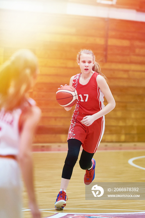Girl basketball player with ball in game