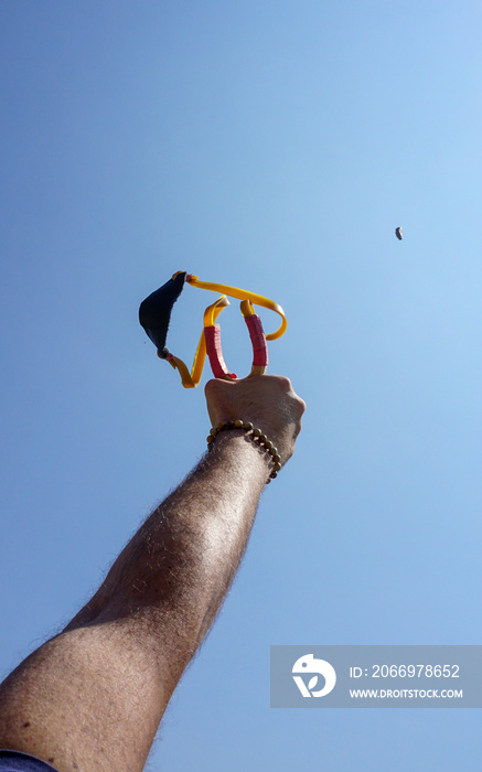 Man using spear thrower throwing rock nature amusement