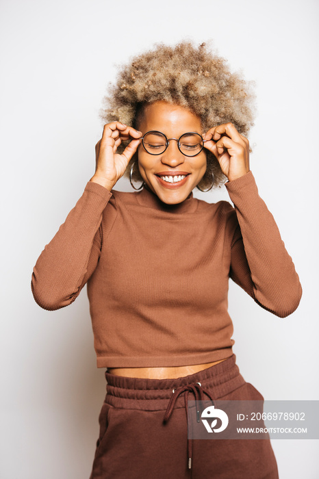 Portrait of Smiling Young woman wearing brown clothes while standing Against White Background