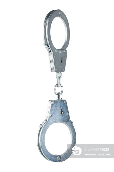 real zinc plated steel police handcuffs closed hanging vertically, isolated on white background