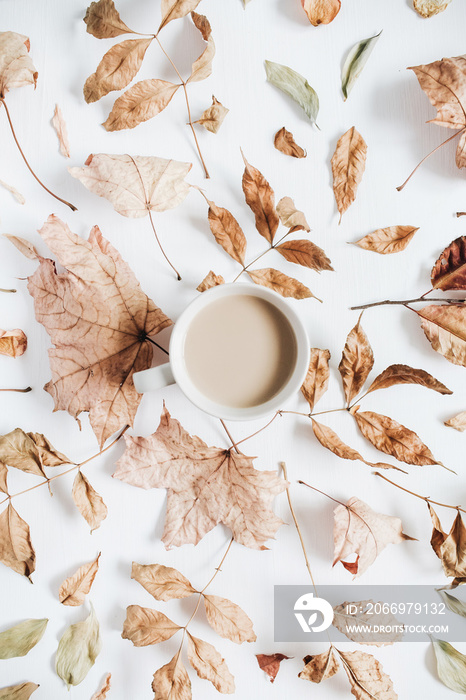 Coffee with milk and dry autumn leaves on white background. Flat lay, top view fall concept.
