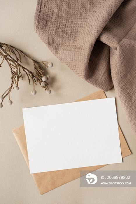 Flatlay of aesthetic Parisian styled business branding template. Blank paper sheet card with mockup copy space, dry flowers branch and cloth on neutral beige background. Flat lay, top view