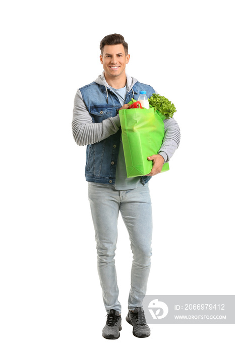 Young man holding bag with food on white background