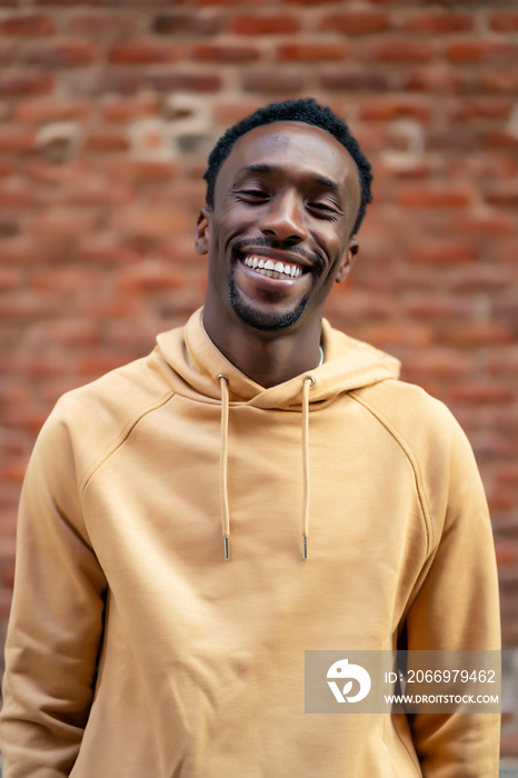 A young man smiling happily on the street