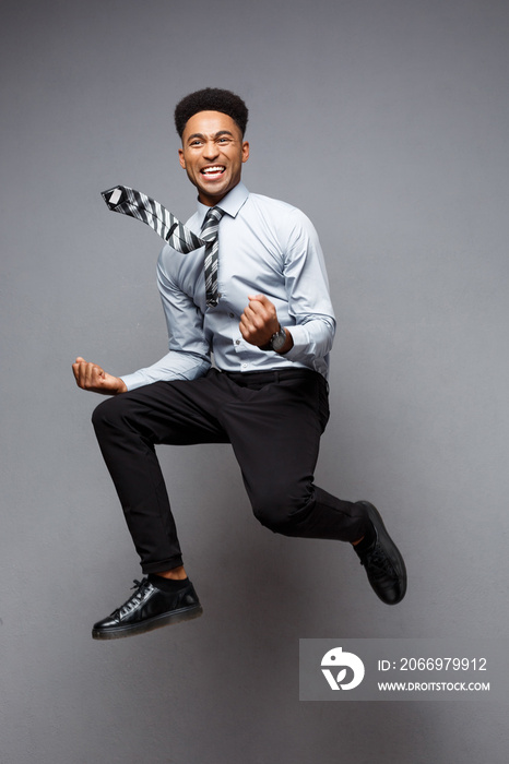 Business Concept - Full length portrait of successful african american businessman happy jumping in the office.