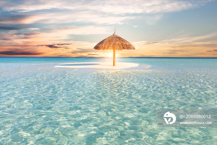 Sandbank island with umbrella in Maldives at sunset