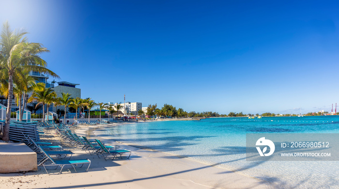 Panoramic view of the beautiful Western Esplanade Beach at Nassau, Bahamas, with calm, turquoise sea and palm trees