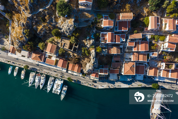 Aerial bird’s eye view photo taken by drone of iconic castle of Symi in Ano chora with views to port of Symi island, Dodecanese, Greece.