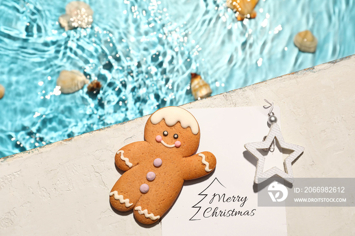 Christmas cookie with greeting card near swimming pool