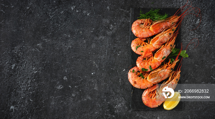 Big red prawns places on a slate plate on black background