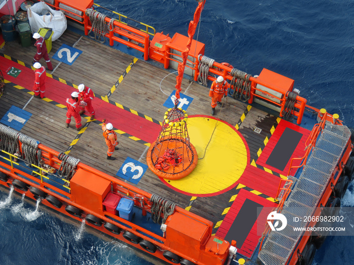 Workers are lifted by the crane to the offshore platform, Transfer crews by personal basket from the platform to crews boat