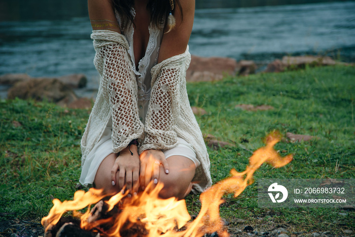 A girl by the bonfire. Camping in the forest. Picnic in nature.