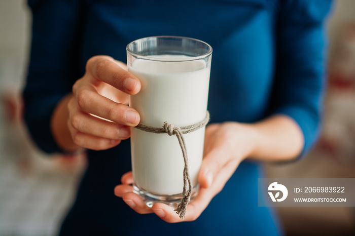 Young woman hands holding a glass of milk.