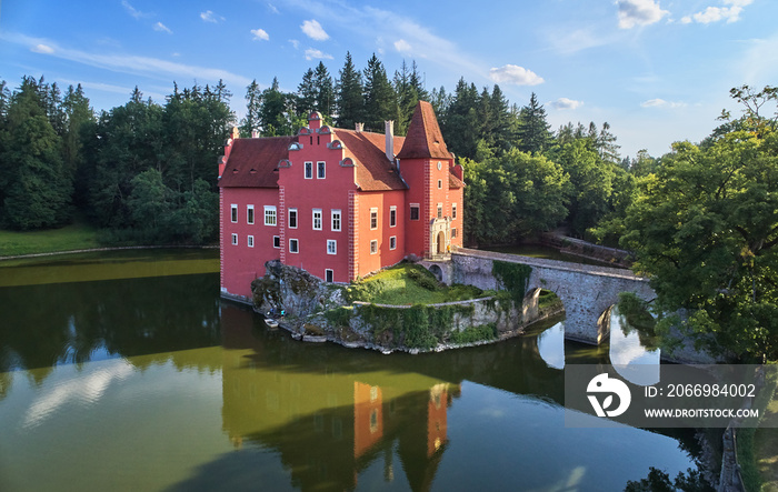 Aerial view of bizarre water castle Cervena Lhota,  picturesque renaissance-style red château standing at the middle of a lake on a rocky island in the czech landscape, south Bohemia, Czech Republic.