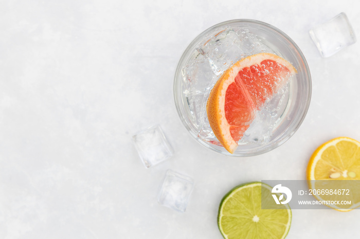 Pink gin tonic vodka soda fruit grapefruit cocktail drink in glass with ice, top view on white background