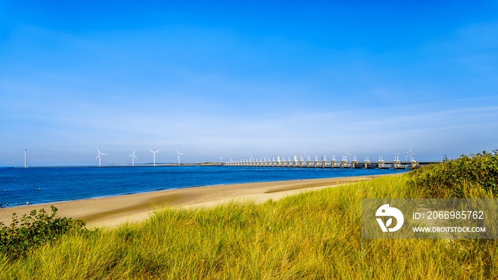 The wide and clean sandy beach at Banjaardstrand along the Oosterschelde inlet at the Schouwen-Duiveland peninsula in Zeeand Province in the Netherlands. The Storm Surge Barrier in the background