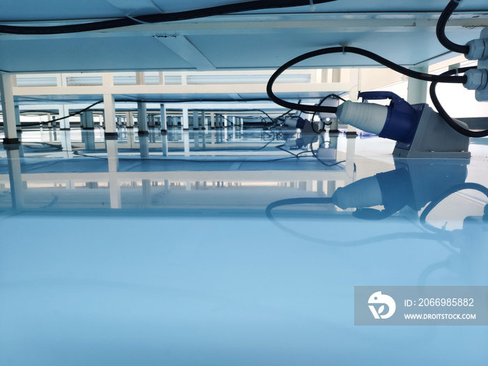 a cable under rack legs at sea blue epoxy floor. (Industrial epoxy floor)
