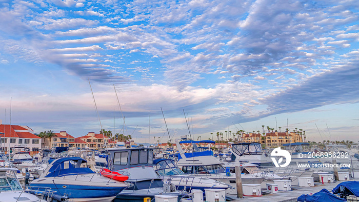 Pano Boats and yachts in Huntington Beach harbor with stunning cloudy blue sky view