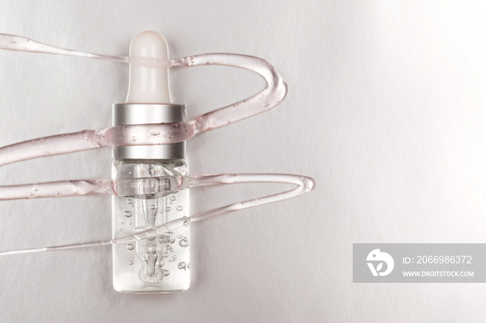 Bottle with hyaluronic acid on silver background. Concept of modern beauty. Flat lay style.