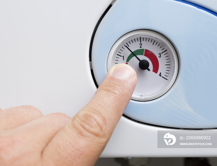 Man’s hand adjusts the heating boiler