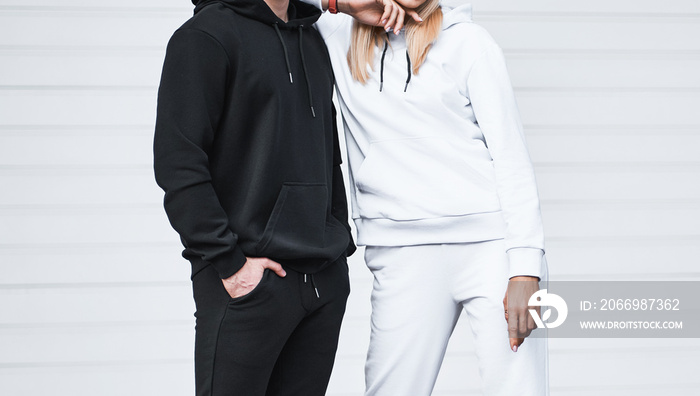 Basic clothing brand mockup. Design template for hoodie and casual sportswear. A woman and man wearing hoodies with no logo. Horizontal sweatshirt mock-up