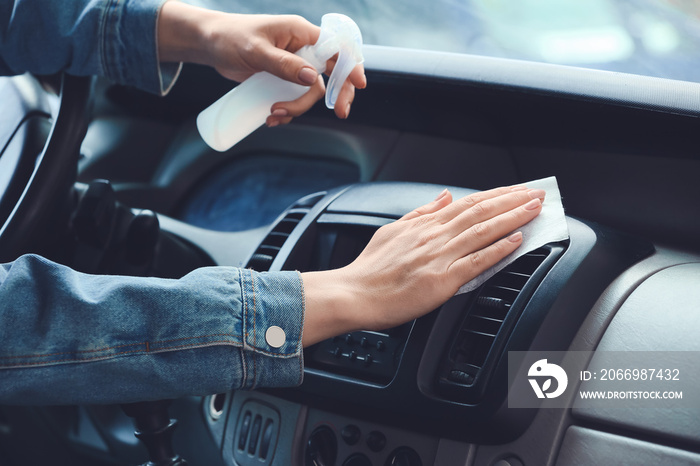 Woman disinfecting salon of car