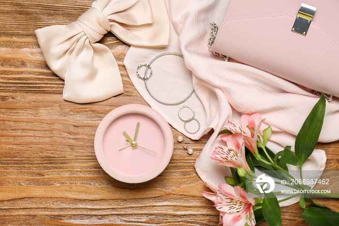 Composition with alarm clock, stylish female accessories and alstroemeria flowers on wooden background