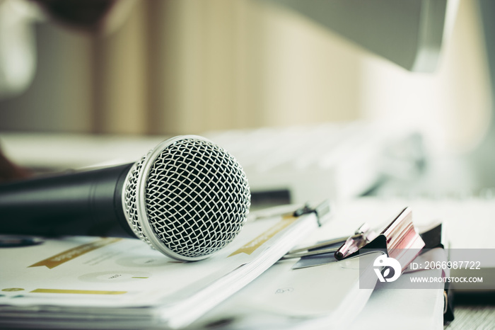 Teacher / speaker hold Microphone with paper document at seminar for speaking or lecture at classroom university with computer desktop on desk. Speech Conference at School Concept. Vintage Tone