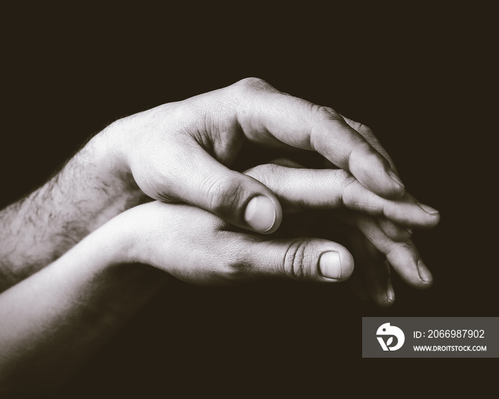 A gentle touch of two hands. Concept of LGBT love, caring, tolerance, etc. Black and white, toned image.