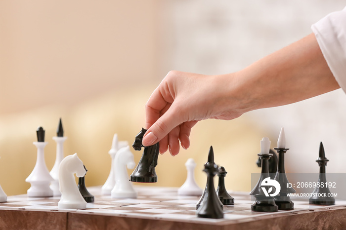 Young woman playing chess at home