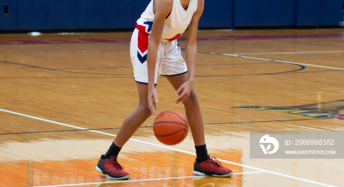 High school basketball player dribbling the ball during a game