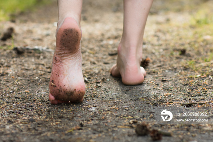 Woman legs walking in summer forest. Barefoot, freedom and health concept.