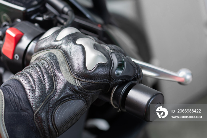 Close up of throttle control hand and brake lever motorcycle, Hands wearing black leather gloves with a protective card grip the brake lever