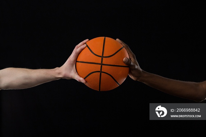 Competitors holding basketball against black background